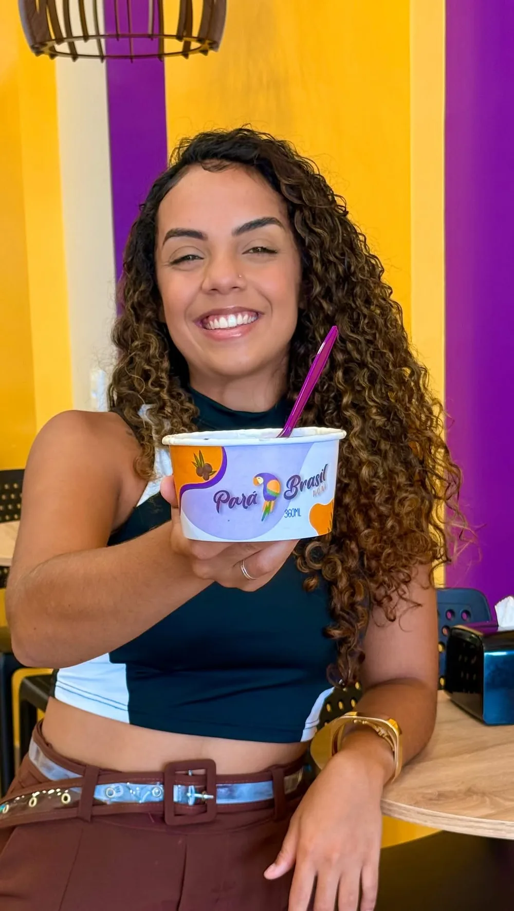 Cliente sorrindo com o pote de açaí do ParáBrasil